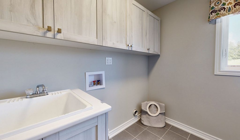 Picture Homes Model Home - Laundry Room with Sink and Storage Shelves