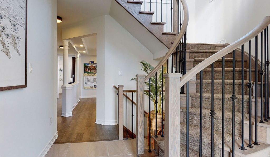 Picture Homes The Hampton Model Home - Bottom of Staircase and Hallways Leading Into Kitchen and Dining Room