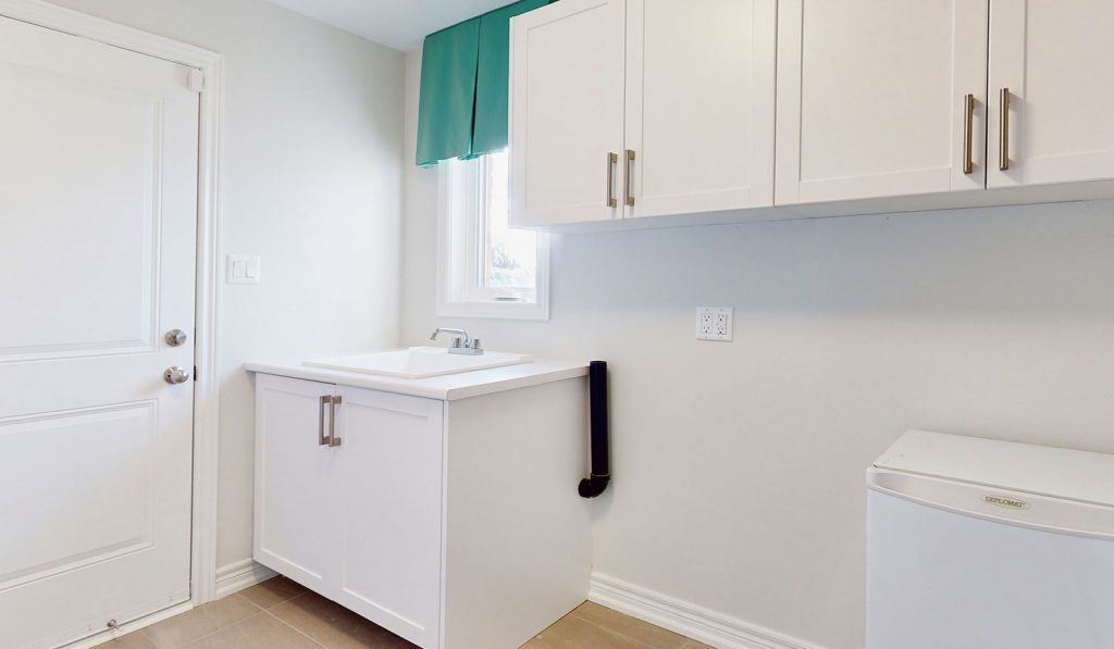 Picture Homes The Hampton Model Home - Laundry Room Sink with Cabinets and Windows