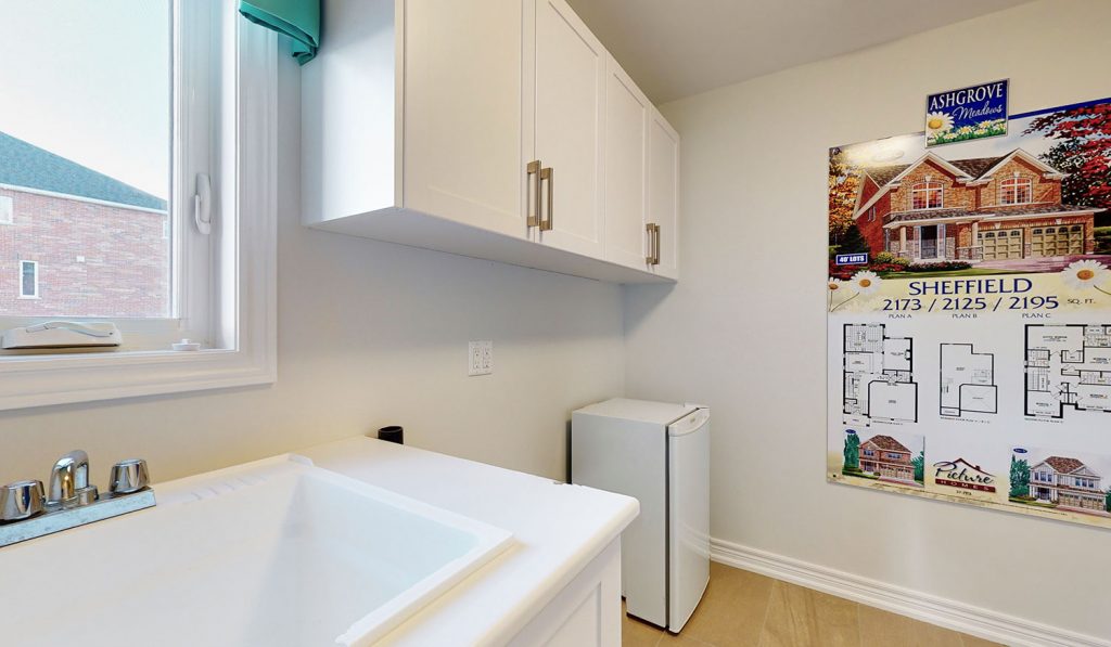 Picture Homes The Hampton Model Home - Laundry Room with White Cabinets