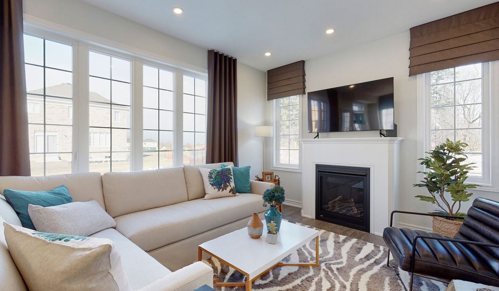 Picture Homes The Hampton Model Home - Family Room Couch, TV, and Fireplace with Large Windows